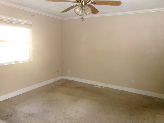 carpeted empty room with crown molding, baseboards, and ceiling fan