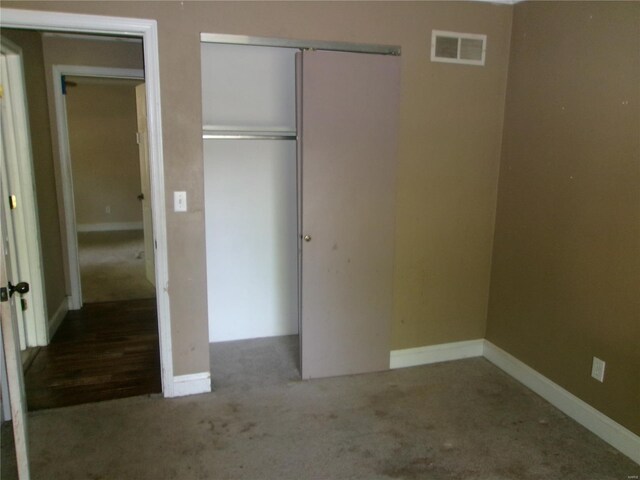 unfurnished bedroom with baseboards, carpet flooring, visible vents, and a closet