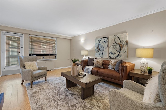 living room featuring crown molding, baseboards, wood finished floors, and radiator heating unit