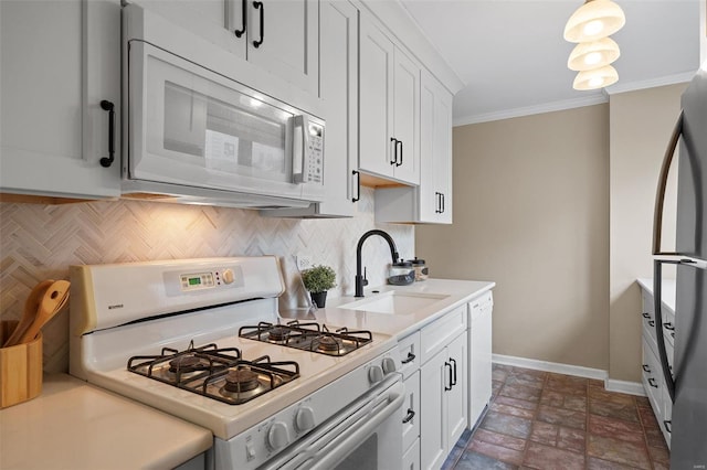 kitchen with backsplash, a sink, baseboards, white cabinets, and white appliances