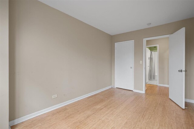 empty room featuring light wood-type flooring and baseboards