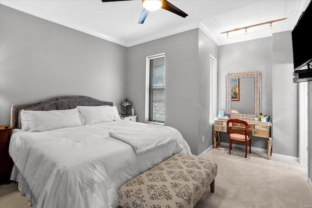 bedroom featuring light colored carpet, track lighting, a ceiling fan, baseboards, and ornamental molding