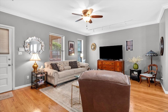 living room featuring crown molding, rail lighting, ceiling fan, and light wood-style floors