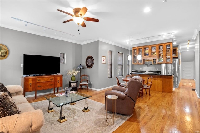 living area featuring crown molding, a ceiling fan, rail lighting, and light wood finished floors