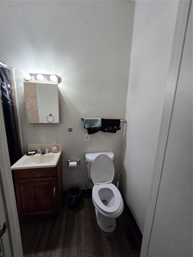bathroom featuring toilet, wood finished floors, and vanity