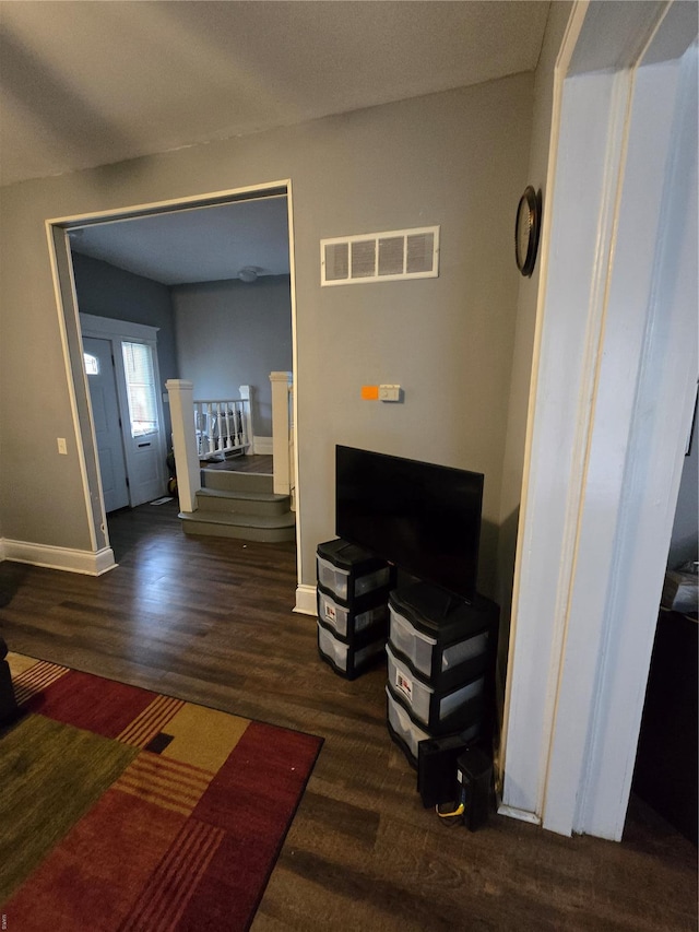 living area featuring wood finished floors, visible vents, stairs, and baseboards