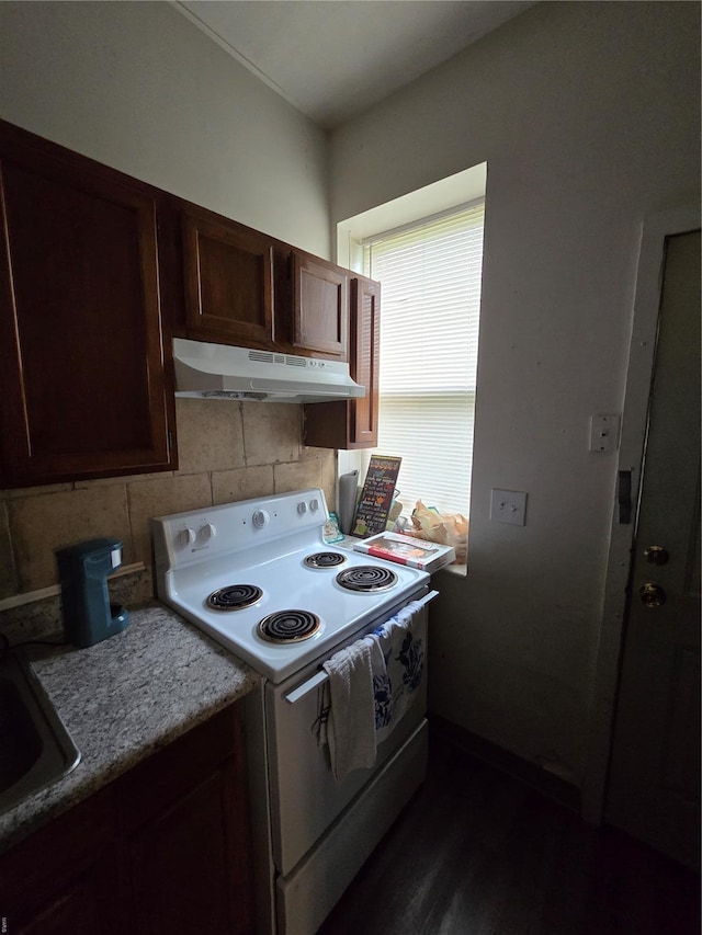 kitchen featuring dark wood-style flooring, under cabinet range hood, decorative backsplash, white range with electric cooktop, and dark brown cabinets