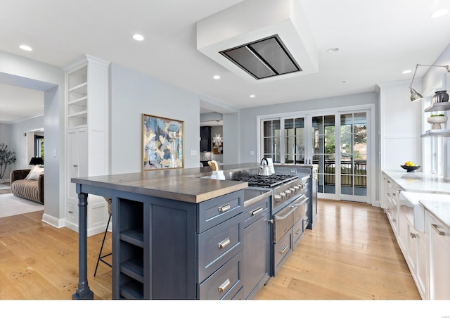 kitchen featuring a breakfast bar area, open shelves, and light wood-style floors