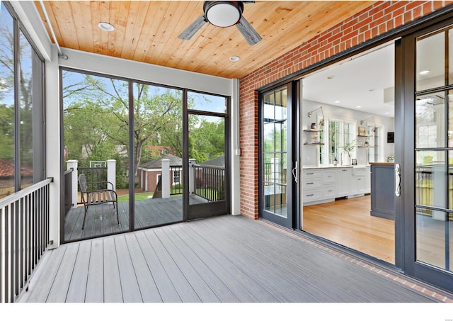 unfurnished sunroom featuring a ceiling fan