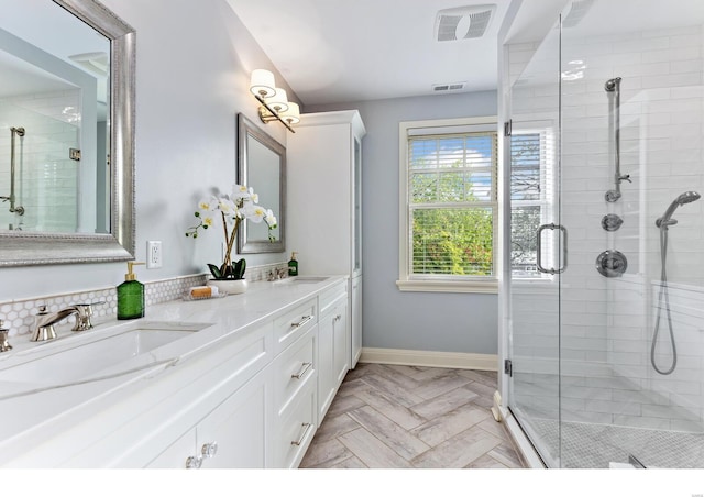 bathroom with a sink, visible vents, and a shower stall