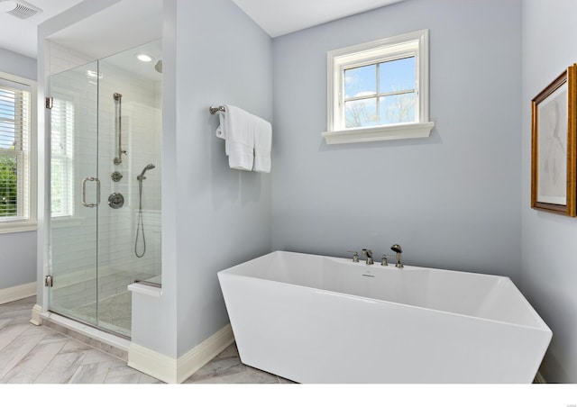 full bathroom with visible vents, a shower stall, a healthy amount of sunlight, and baseboards