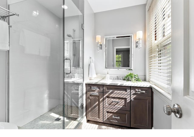 full bathroom featuring a healthy amount of sunlight, a shower stall, and vanity
