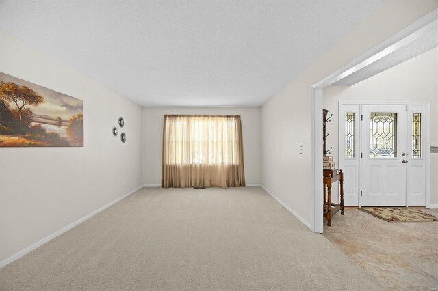 carpeted entrance foyer featuring baseboards