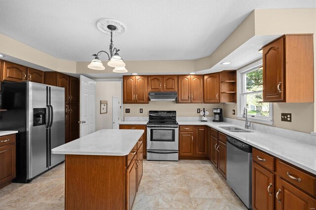 kitchen with a sink, an inviting chandelier, appliances with stainless steel finishes, light countertops, and under cabinet range hood