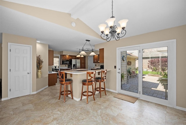 kitchen featuring a peninsula, stainless steel fridge, an inviting chandelier, black microwave, and light countertops