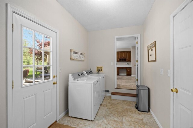 clothes washing area featuring separate washer and dryer, baseboards, and laundry area