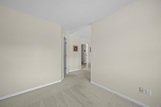 carpeted empty room featuring baseboards