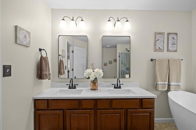bathroom featuring a freestanding bath, a shower stall, double vanity, and a sink