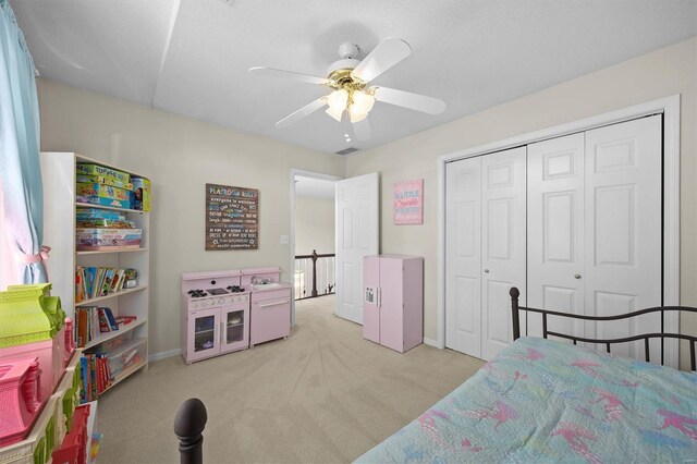 bedroom with baseboards, a closet, a ceiling fan, and light colored carpet