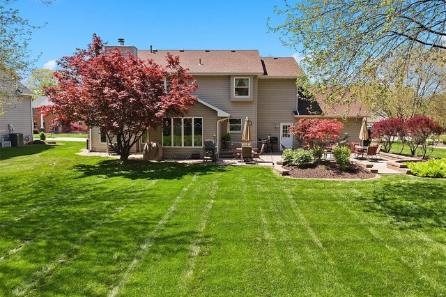 back of property featuring a patio area, a lawn, and central air condition unit