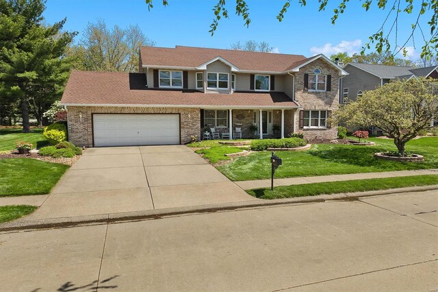 traditional-style home with a shingled roof, concrete driveway, a porch, brick siding, and a front yard