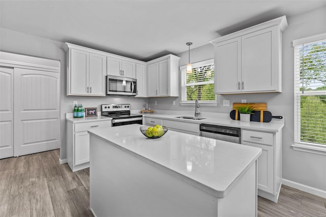 kitchen featuring a sink, stainless steel appliances, light countertops, and white cabinets
