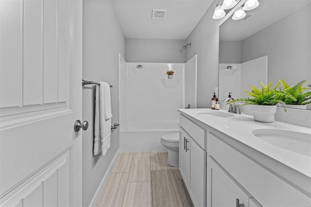 bathroom with double vanity, toilet, a sink, washtub / shower combination, and visible vents