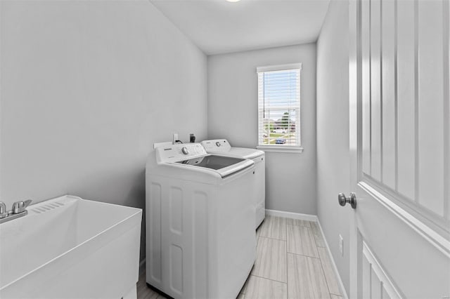 laundry room featuring washer and dryer, baseboards, laundry area, and a sink