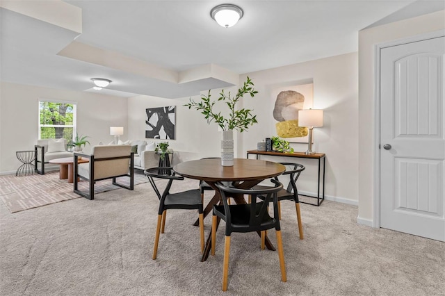 dining space with light colored carpet and baseboards