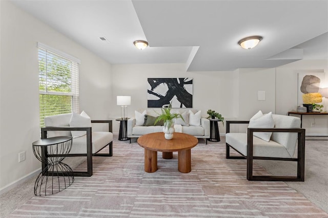 carpeted living area with baseboards