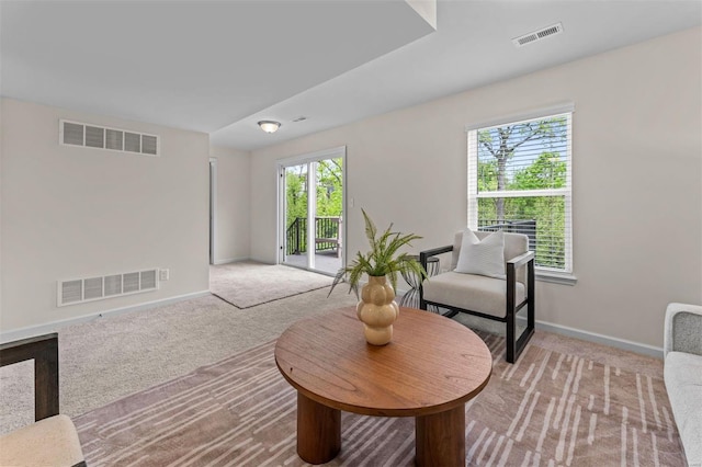 sitting room with carpet, visible vents, and baseboards