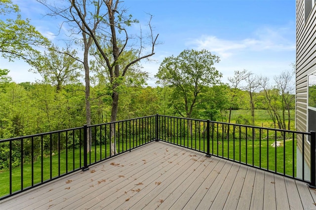 deck with a wooded view and a lawn