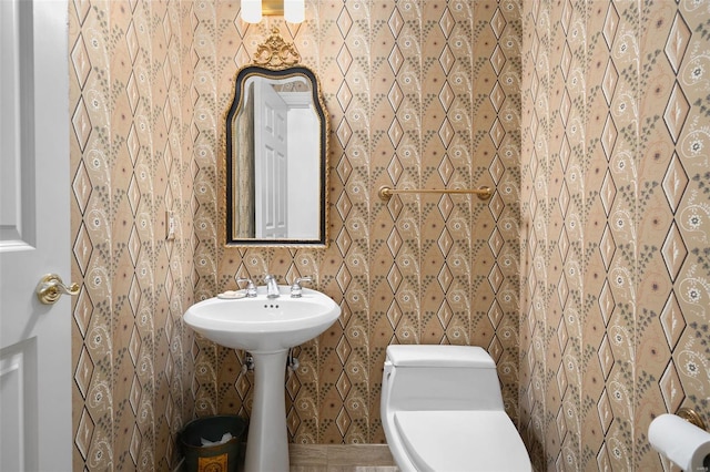bathroom with wallpapered walls and toilet