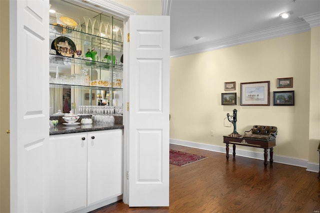 bar with baseboards, ornamental molding, and dark wood-style flooring
