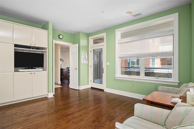 living area featuring baseboards, dark wood finished floors, and visible vents
