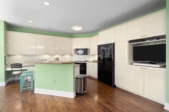 kitchen featuring a breakfast bar area, dark wood-style floors, recessed lighting, white cabinets, and black appliances