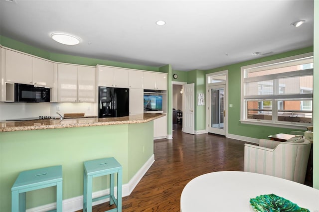 kitchen with white cabinetry, baseboards, dark wood-style floors, and black appliances