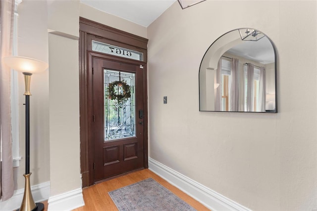 foyer entrance with baseboards and light wood-type flooring