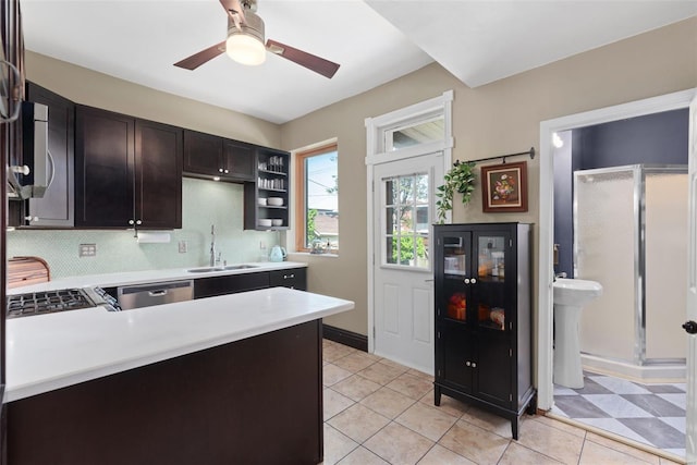 kitchen featuring dark brown cabinets, a sink, light countertops, a ceiling fan, and decorative backsplash