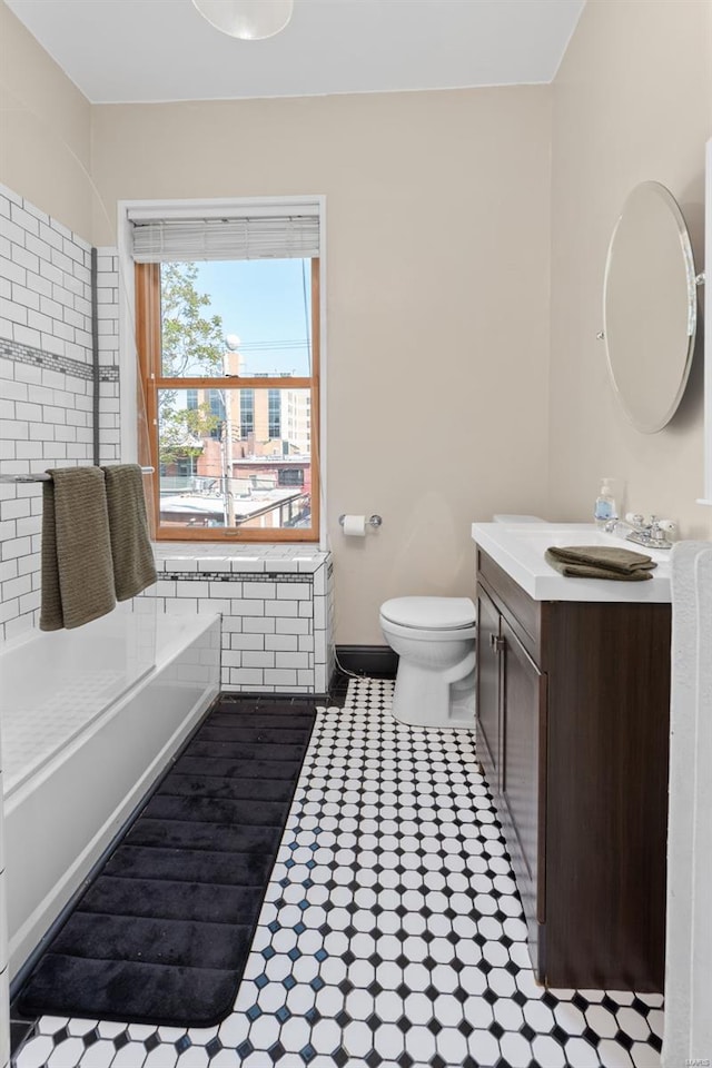 full bath featuring vanity, tile patterned flooring, a bathtub, and toilet