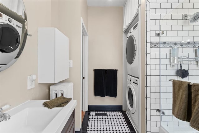 laundry area with laundry area, stacked washing maching and dryer, and baseboards