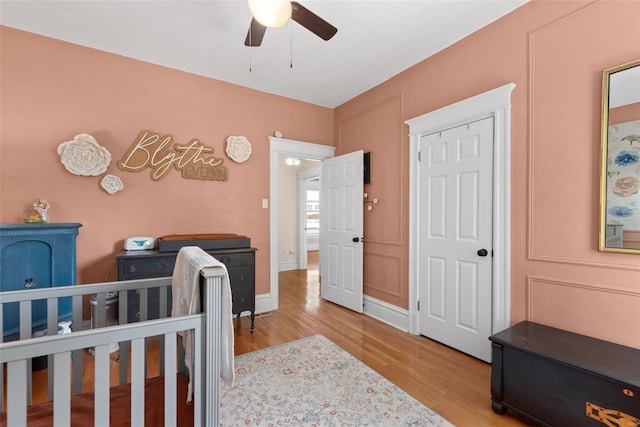bedroom with a ceiling fan, baseboards, and wood finished floors