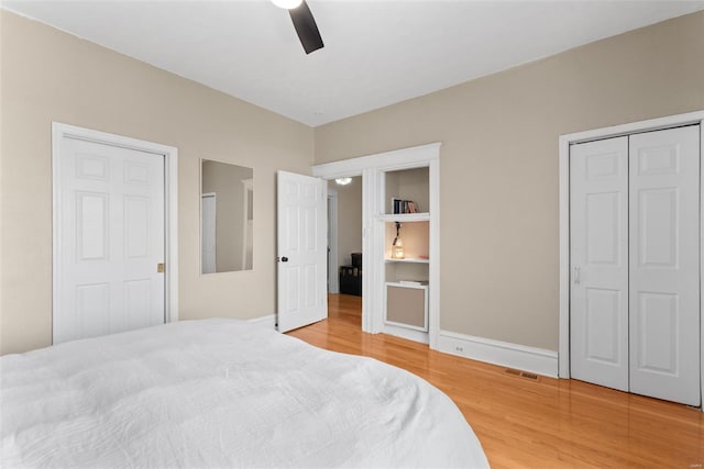 bedroom with ceiling fan, baseboards, visible vents, and light wood-style flooring