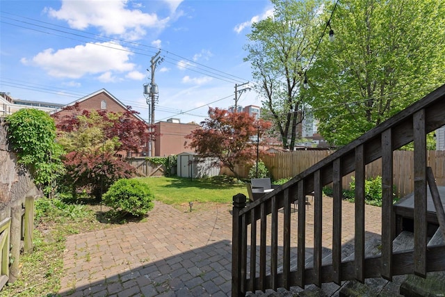 view of patio / terrace with a fenced backyard, a shed, and an outbuilding