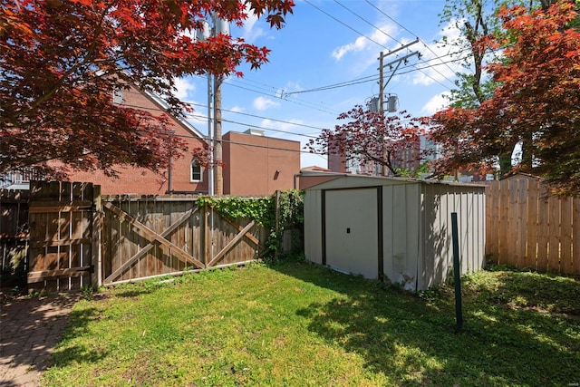 view of yard featuring an outbuilding, a fenced backyard, and a storage unit