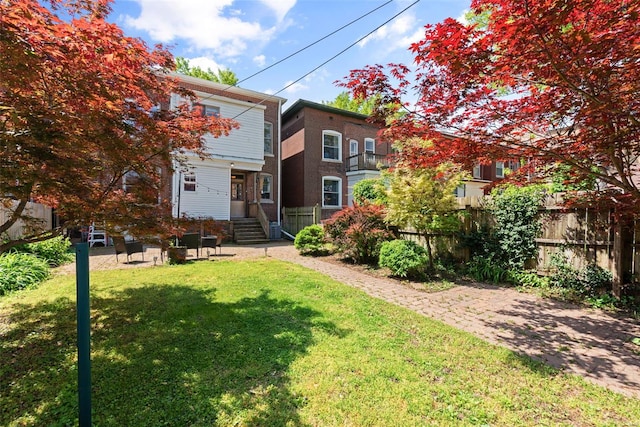 exterior space with a lawn, fence, and entry steps