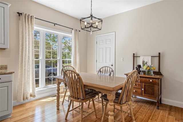 dining room featuring baseboards, a chandelier, and light wood finished floors