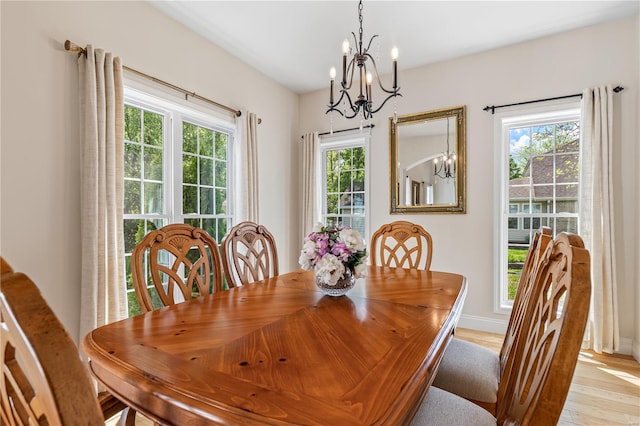 dining area with an inviting chandelier, baseboards, and light wood finished floors