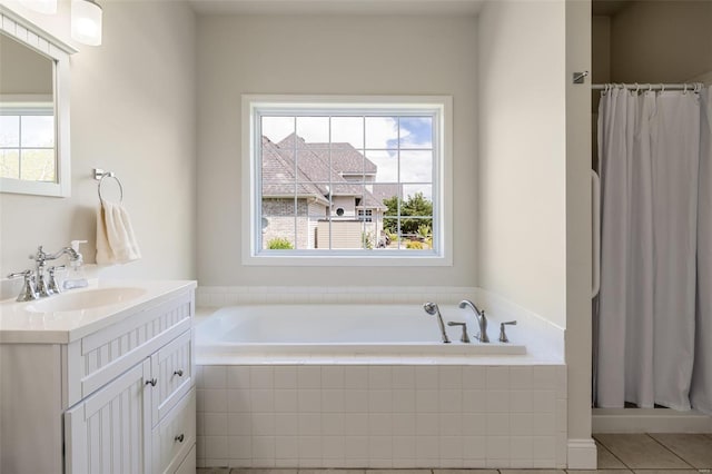 full bathroom with a stall shower, tile patterned flooring, a garden tub, and vanity