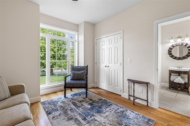 living area featuring light wood-type flooring, baseboards, and a wealth of natural light